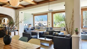 Amplia sala de estar con techo de madera, ventanas grandes y un moderno conjunto de sofás.