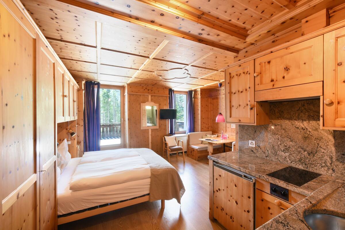 Eine Holzhütte mit einem Bett, einem Essbereich und einer Küche.