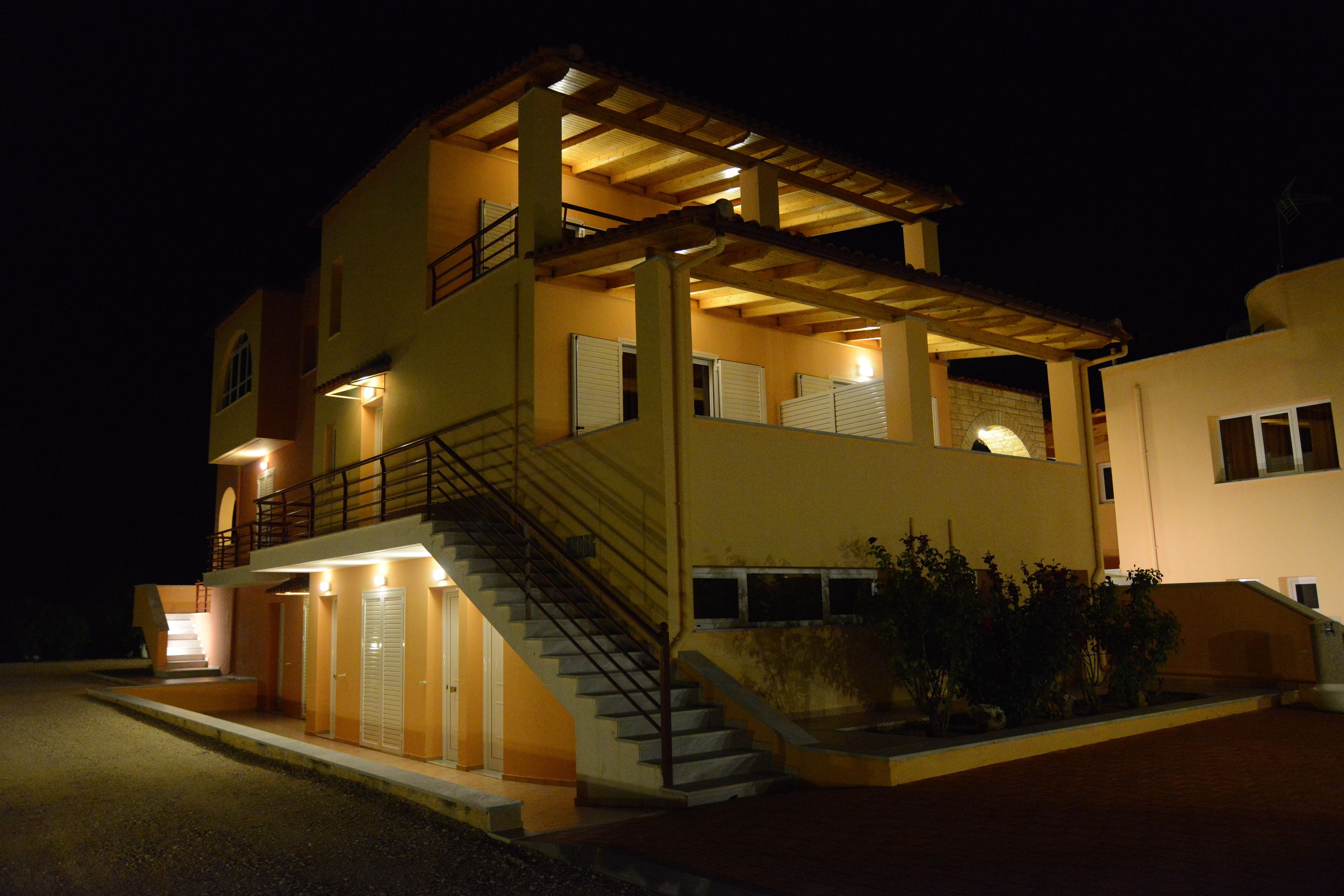A two-story building with a staircase leading to the upper level, a covered outdoor area, and a gated entrance.