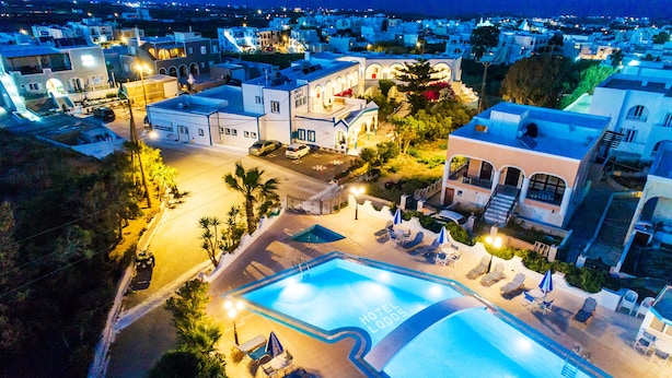 Hotel amb piscina, gandules i zona exterior ben il·luminada.