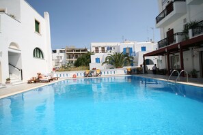 Una piscina al aire libre, tumbonas