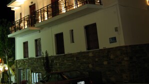 A multi-story hotel with balconies and a stone facade. - Iliovasilema (Naxos)