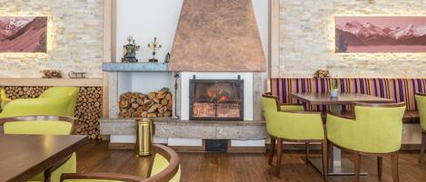 Un comedor acogedor con chimenea, mobiliario de madera y paredes de piedra.