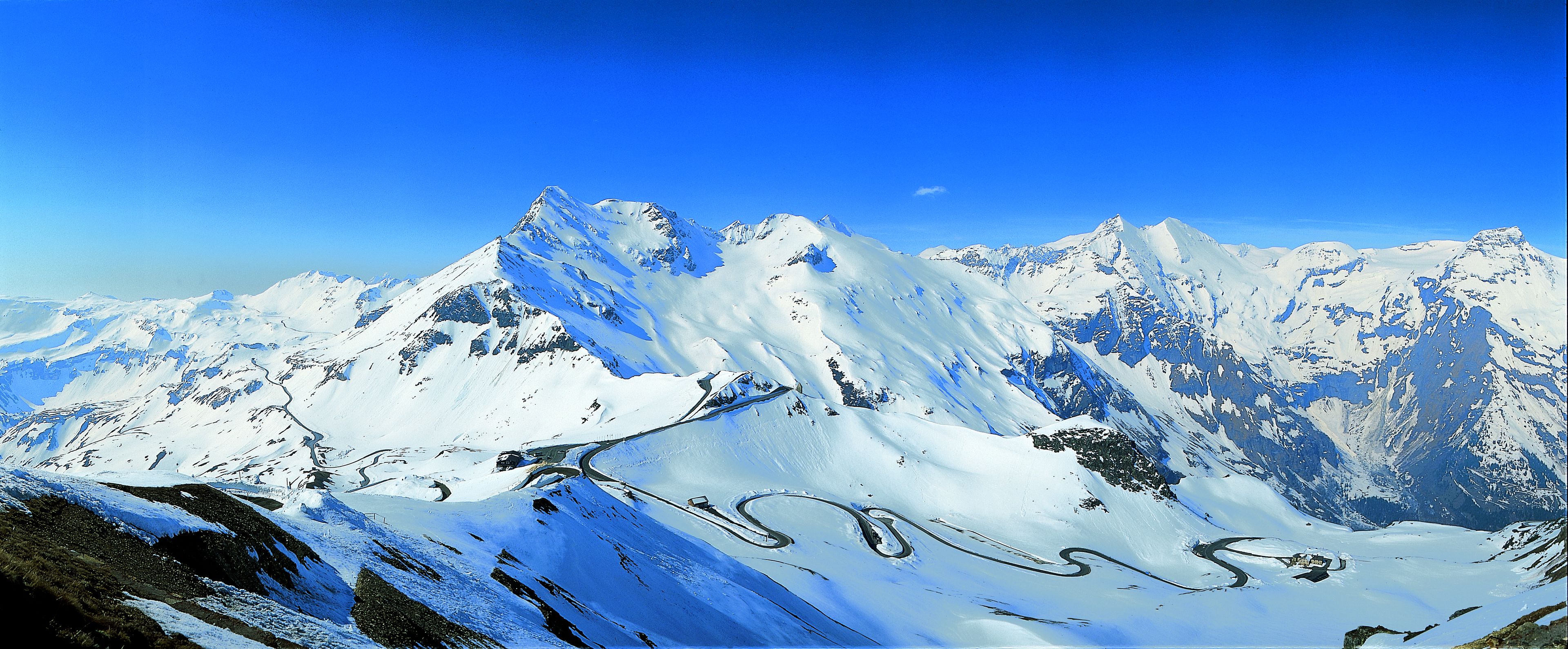 Une chaîne de montagnes enneigée sous un ciel dégagé.