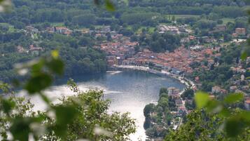 A riverside town with red-roofed buildings, a bridge, and lush greenery.