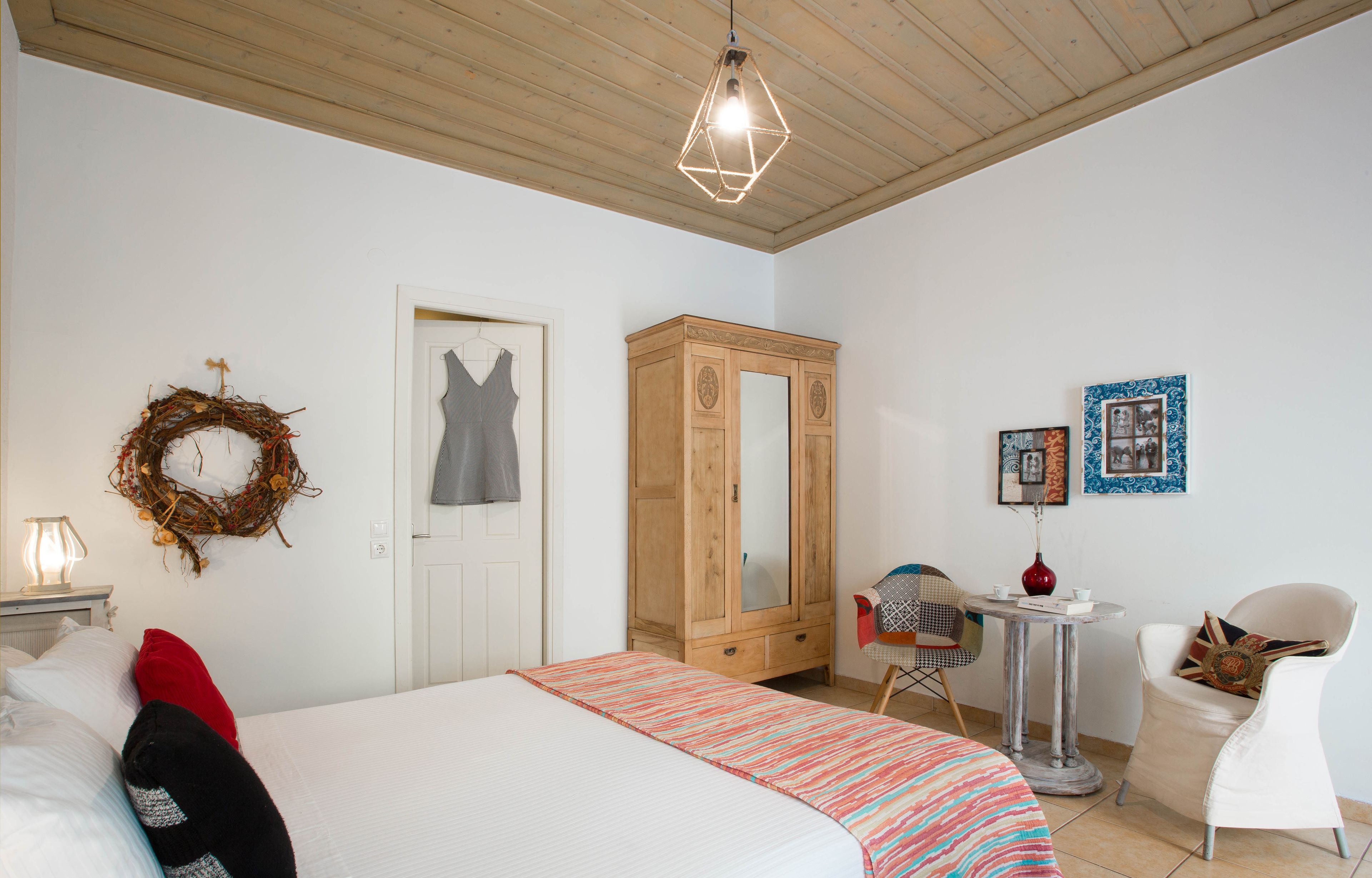 Un dormitorio con cama, armario, escritorio y silla.