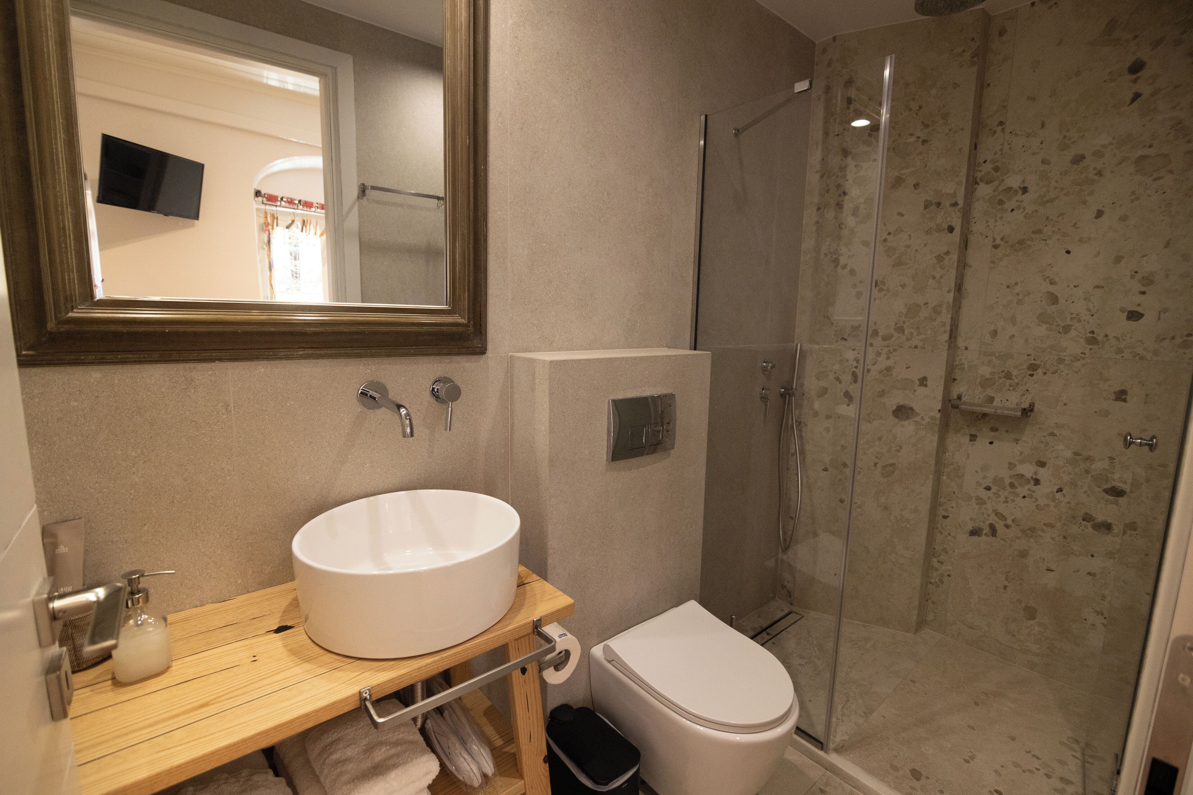 A bathroom with a white sink, toilet, and a glass shower enclosure.