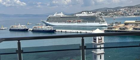 Blick auf ein Kreuzfahrtschiff, das im Hafen liegt, mit einer Stadtkulisse im Hintergrund.