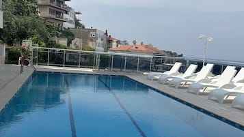 Piscine extérieure, parasols de plage, chaises longues