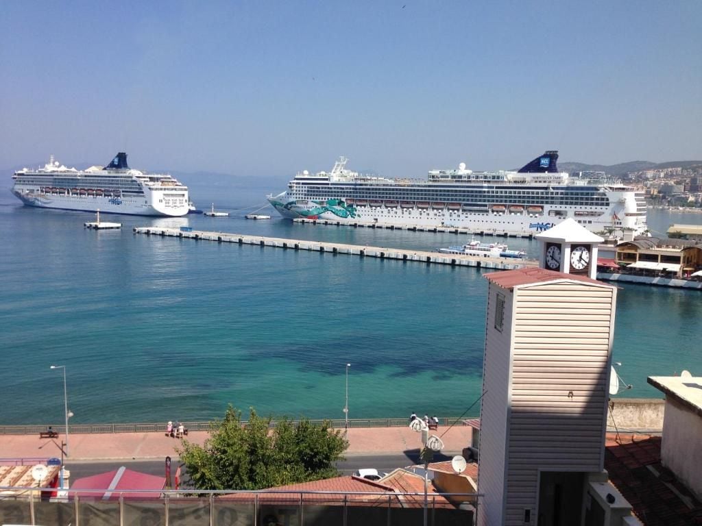 A harbor with two large cruise ships docked at a pier.