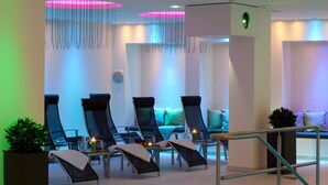 Un área de spa moderna con sillones de descanso, una recepción y una escalera.