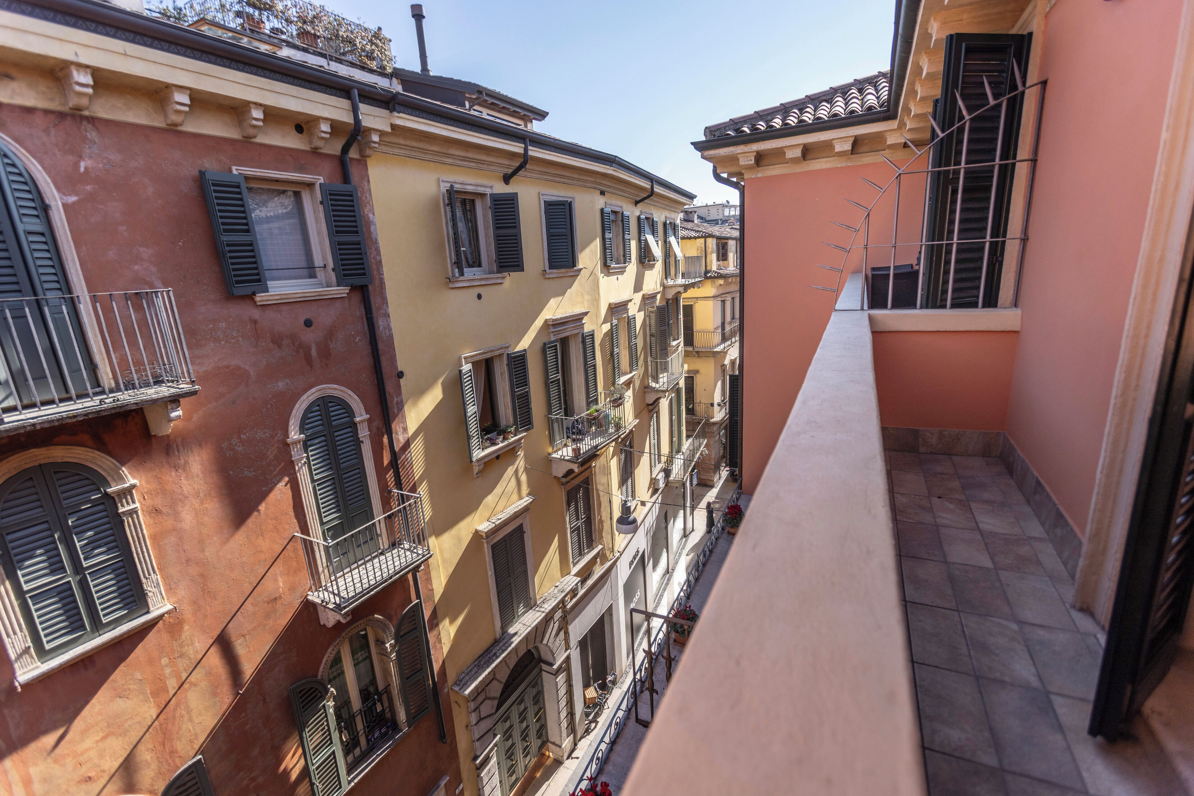 A narrow alleyway between buildings with balconies and windows.