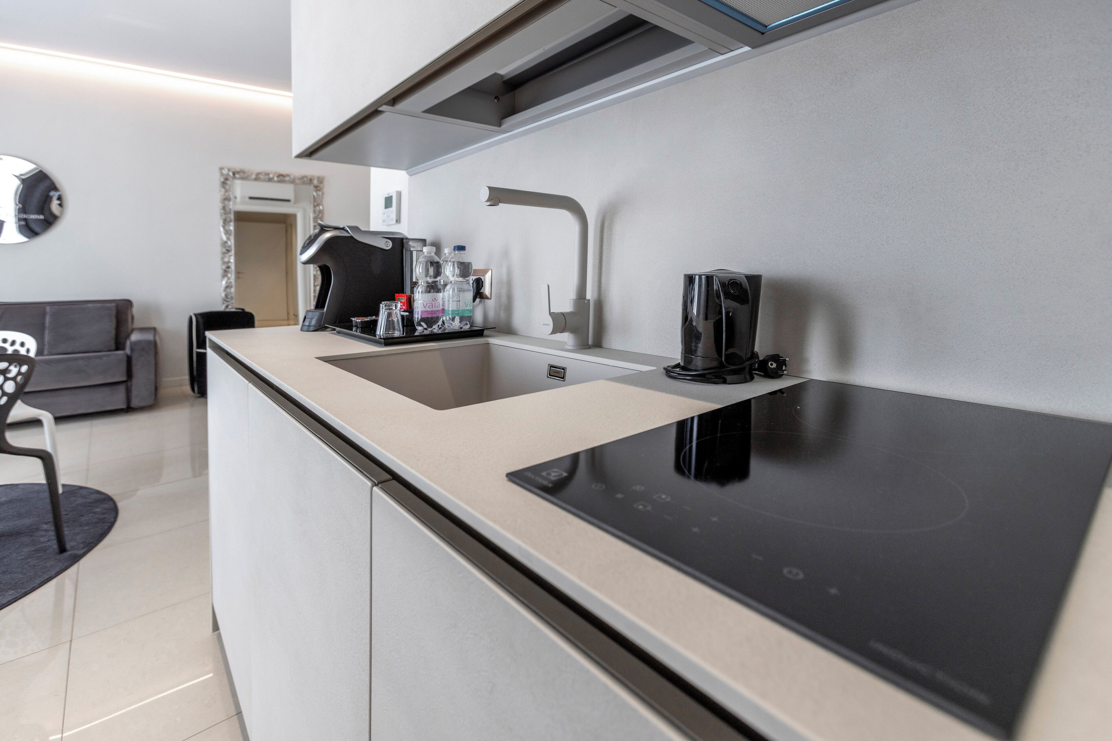 A modern kitchen with a built-in stove, a sink, and a coffee maker.