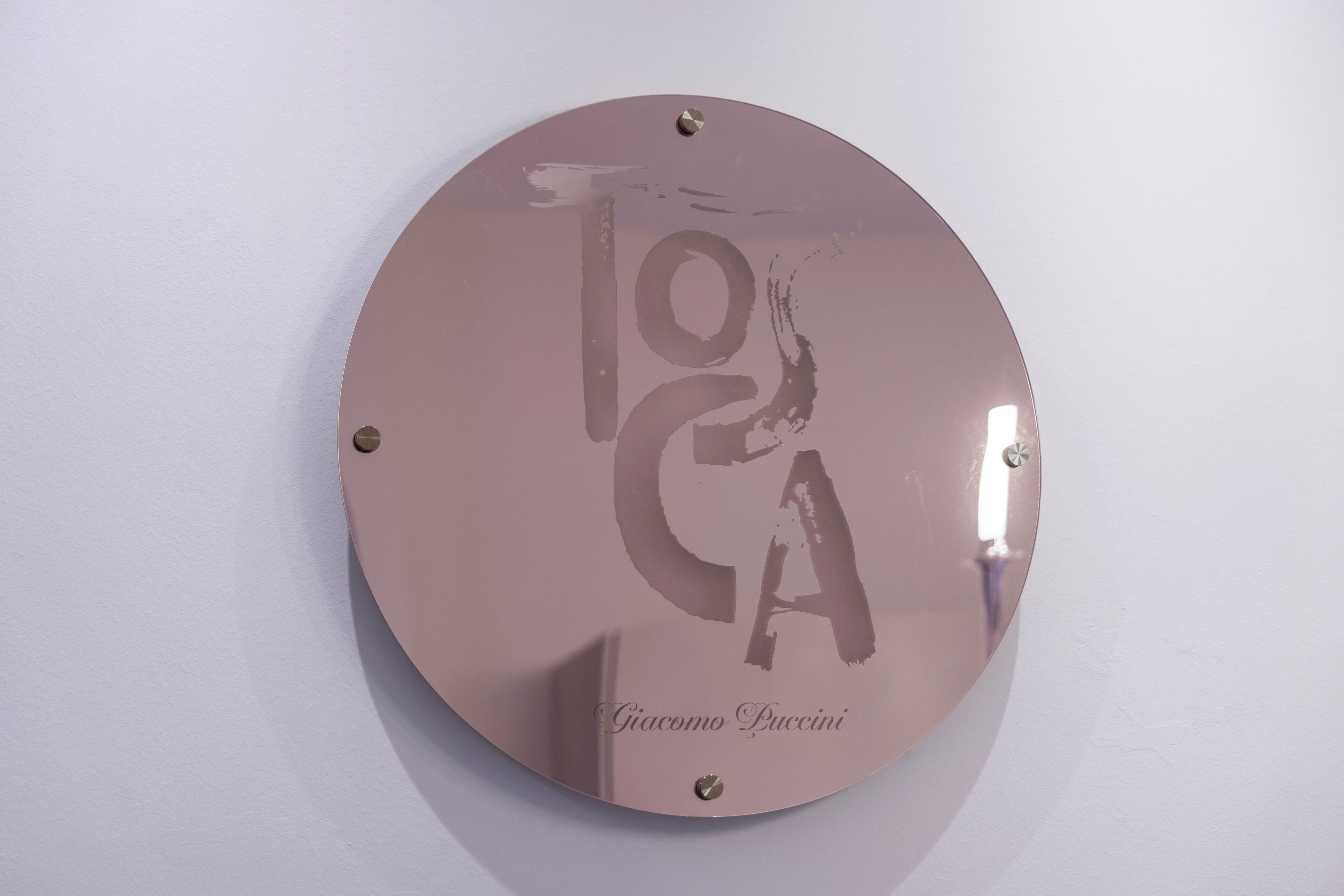Una placa metálica circular con el texto 