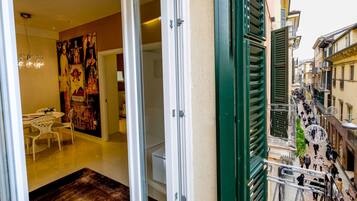 A room with a dining area, a large poster, and a view of a busy street outside.