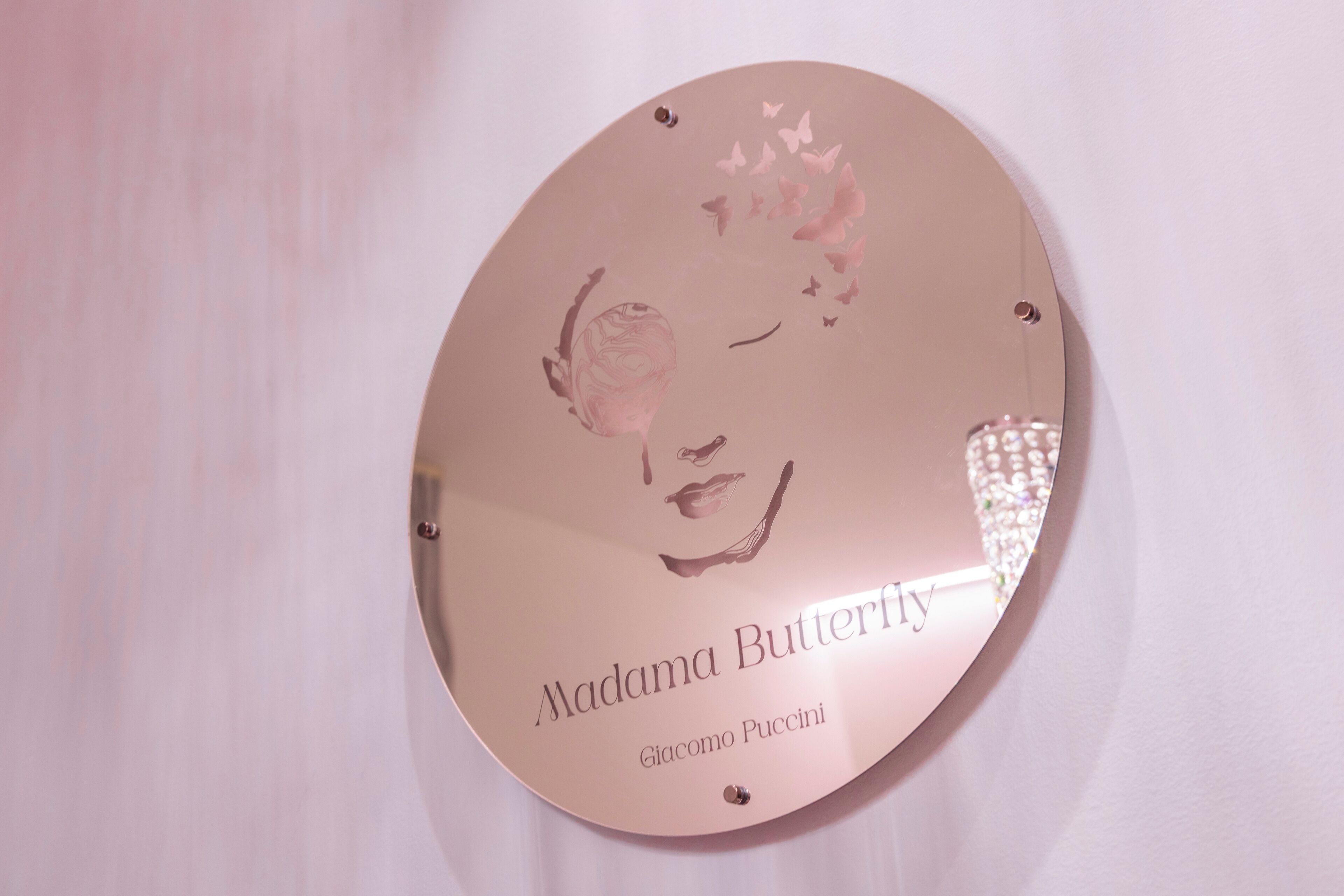 Une plaque circulaire portant le portrait d’une femme et les inscriptions « Madama Butterfly » et « Giacomo Puccini ».
