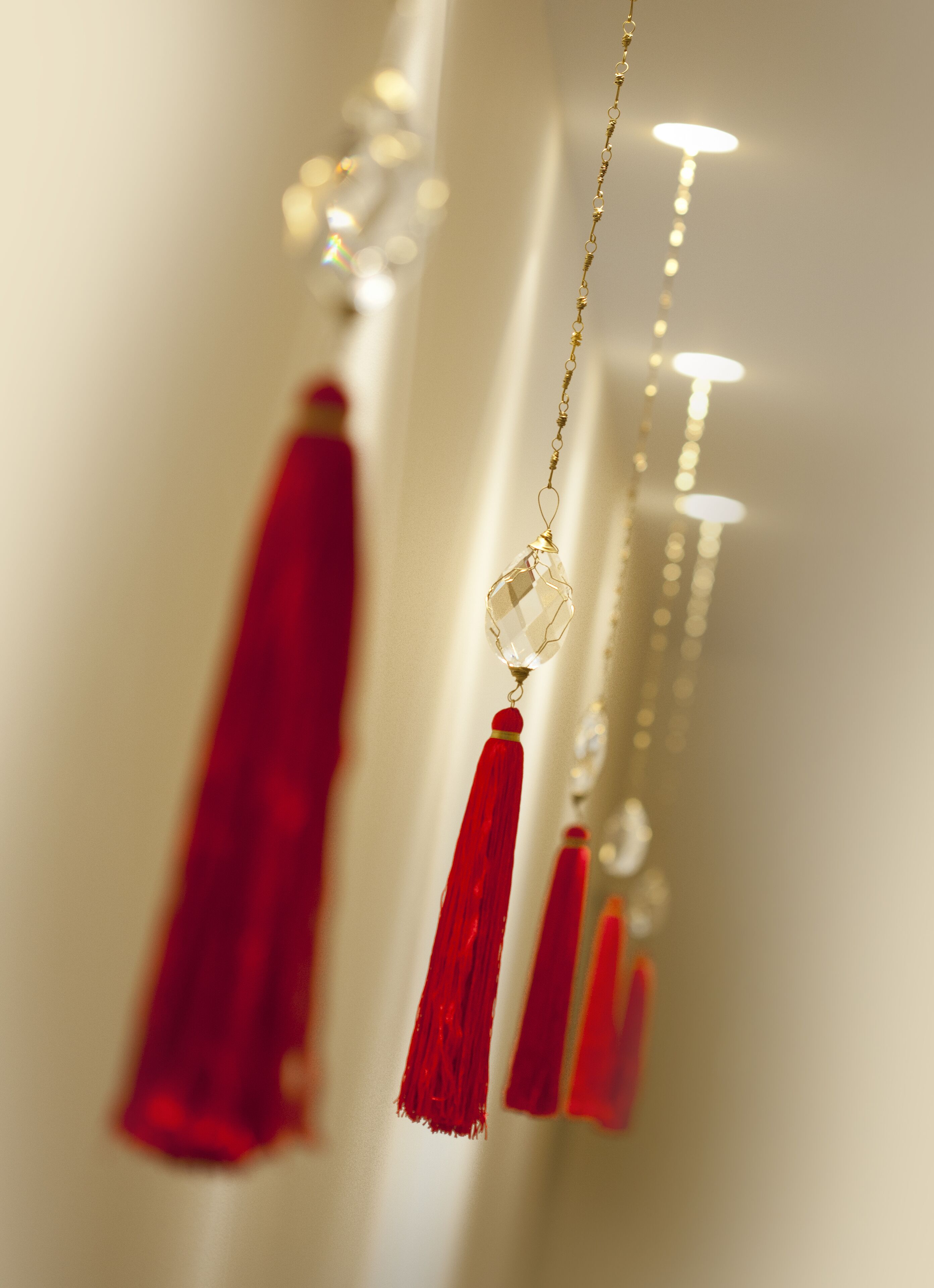 A close-up of a red tassel hanging from a gold chain.
