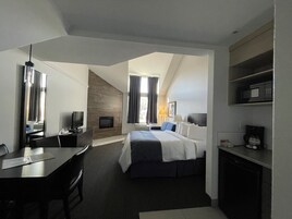 Habitación de hotel con cama, escritorio, televisor y microondas.