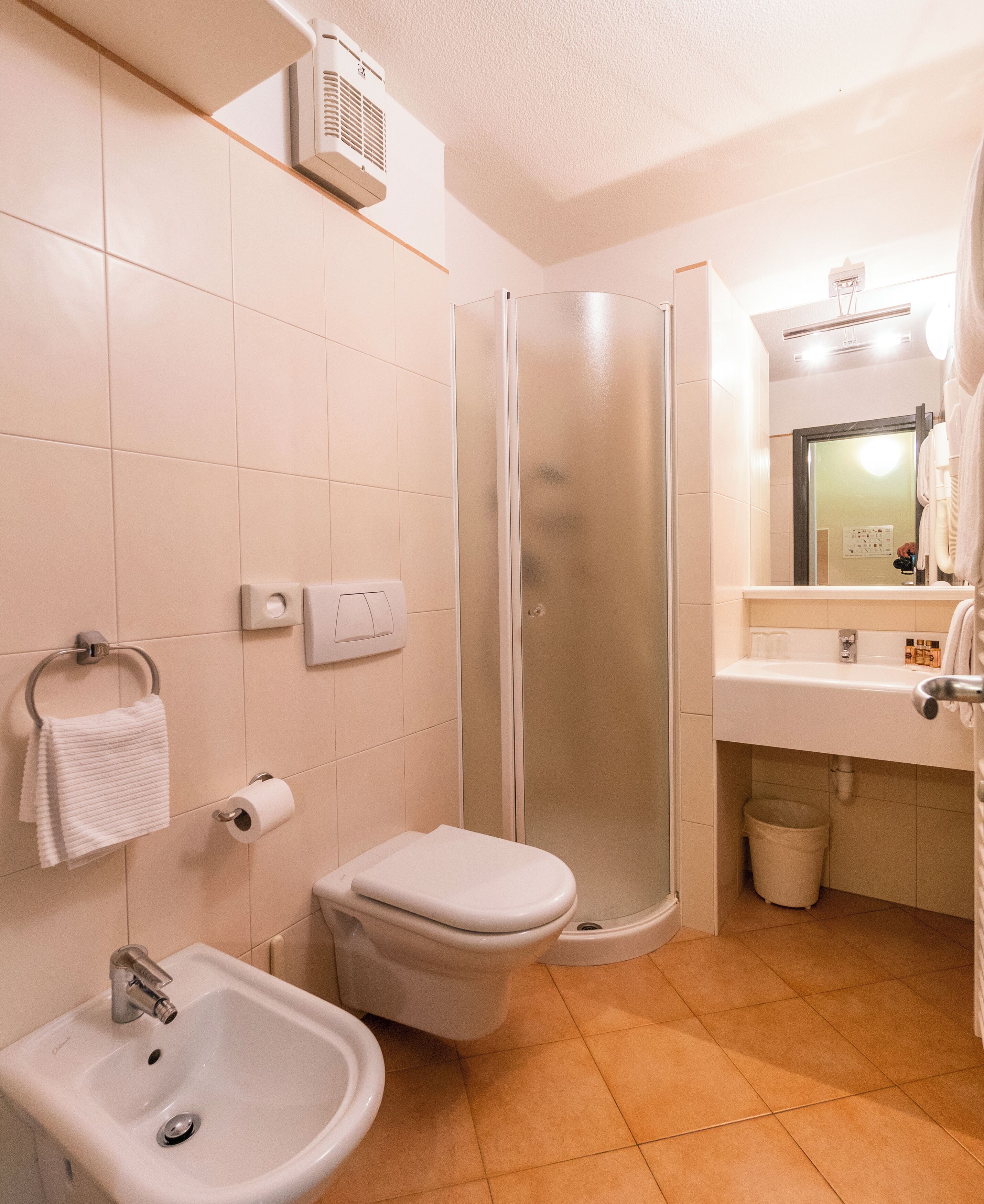 A bathroom with a toilet, sink, and shower.