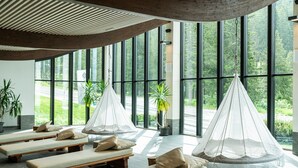 A spa area with multiple sunbeds and a hanging canopy. - Ambiez Residence (Pinzolo)