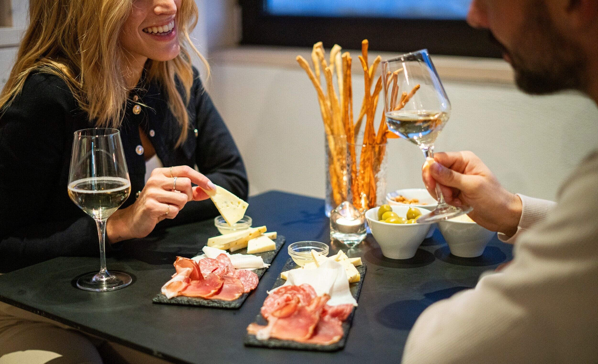 Una mesa de comedor con diversos alimentos y copas de vino.