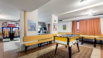 Relax in a spacious room with a foosball table, bench, and framed artworks.