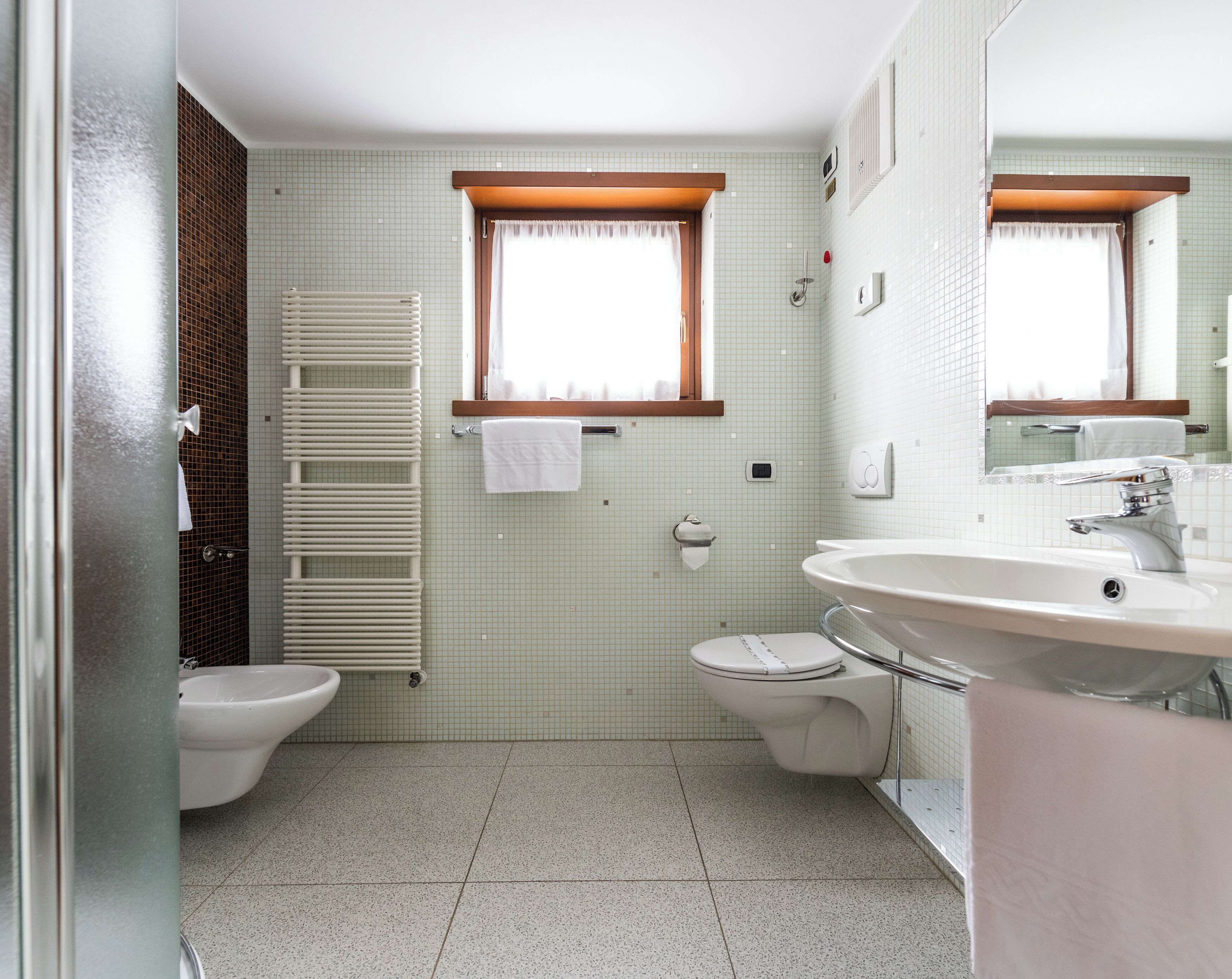 Un baño con inodoro, bidé y lavamanos.