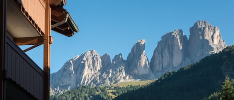 Un paysage de montagne avec des pics rocheux et une structure de bâtiment en bois.