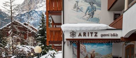 A hotel with a mountain view, wooden balconies, and a mural of a snowy landscape.