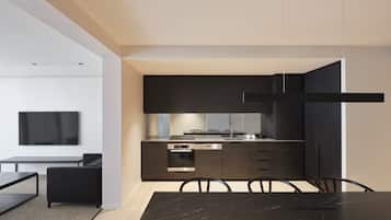 A modern kitchen with dark cabinetry, a black dining table, and a minimalist design.