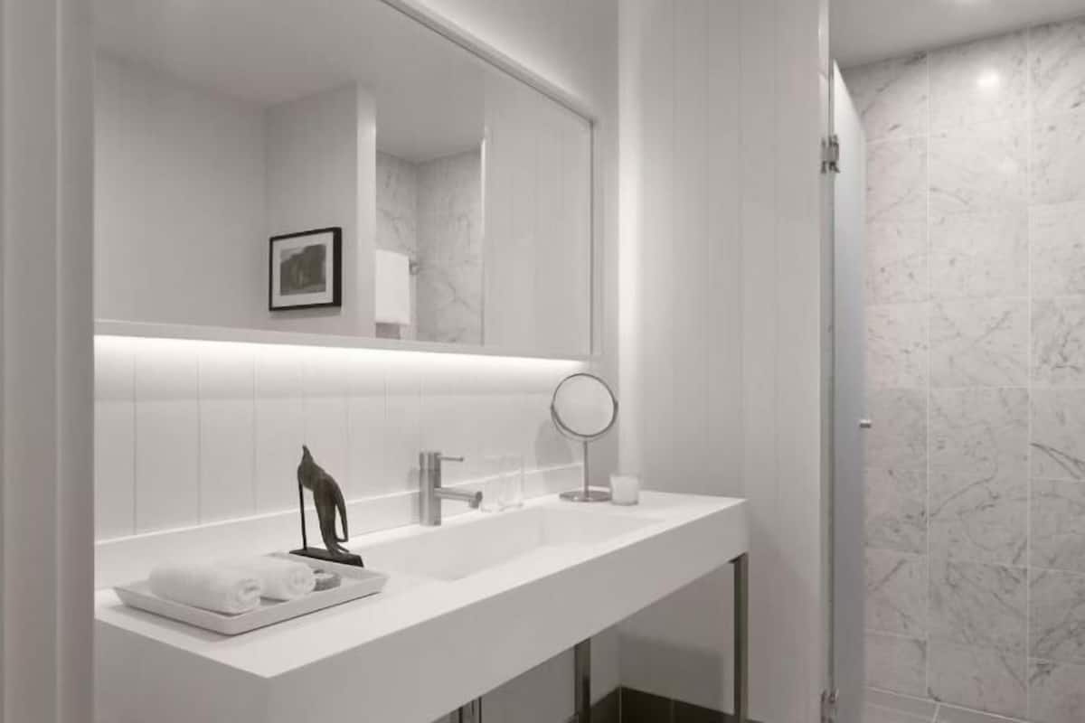Badkamer | Een douche, designer toiletartikelen, een haardroger, badjassen