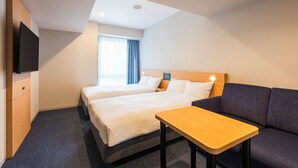 Una habitación de hotel con dos camas, un sofá, un televisor y una mesita.