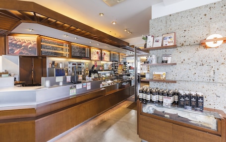 A coffee shop interior with a counter, menu boards, and shelves with beverages.