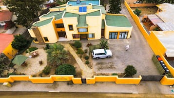 Stunning residential building with a central courtyard surrounded by lush greenery and palm trees.