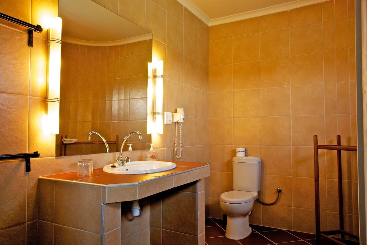 Ein Badezimmer mit Waschbecken, Spiegel und Toilette.