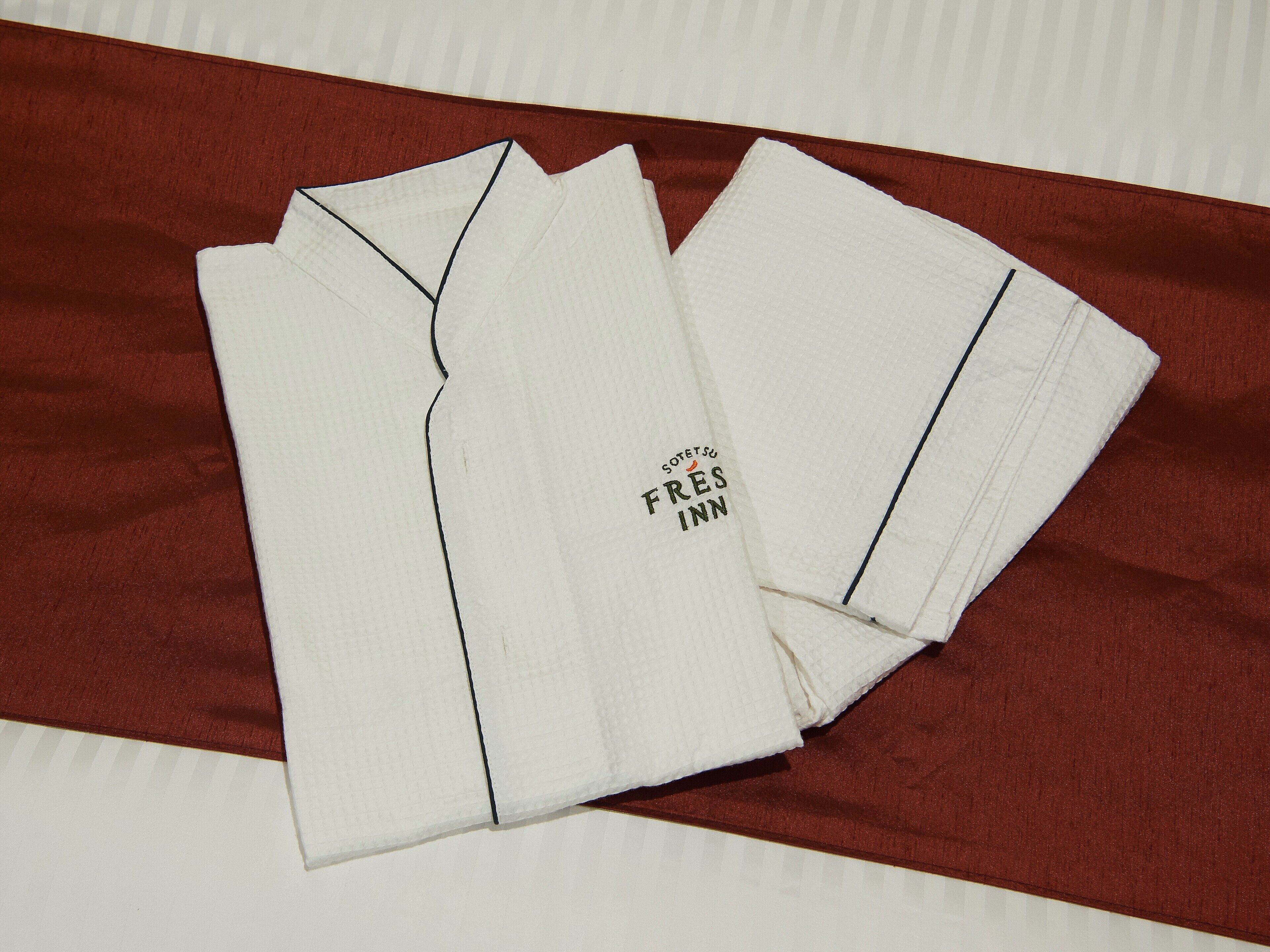 A neatly folded white shirt with a visible text logo on the front.