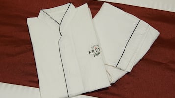 A neatly folded white shirt with a visible text logo on the front.