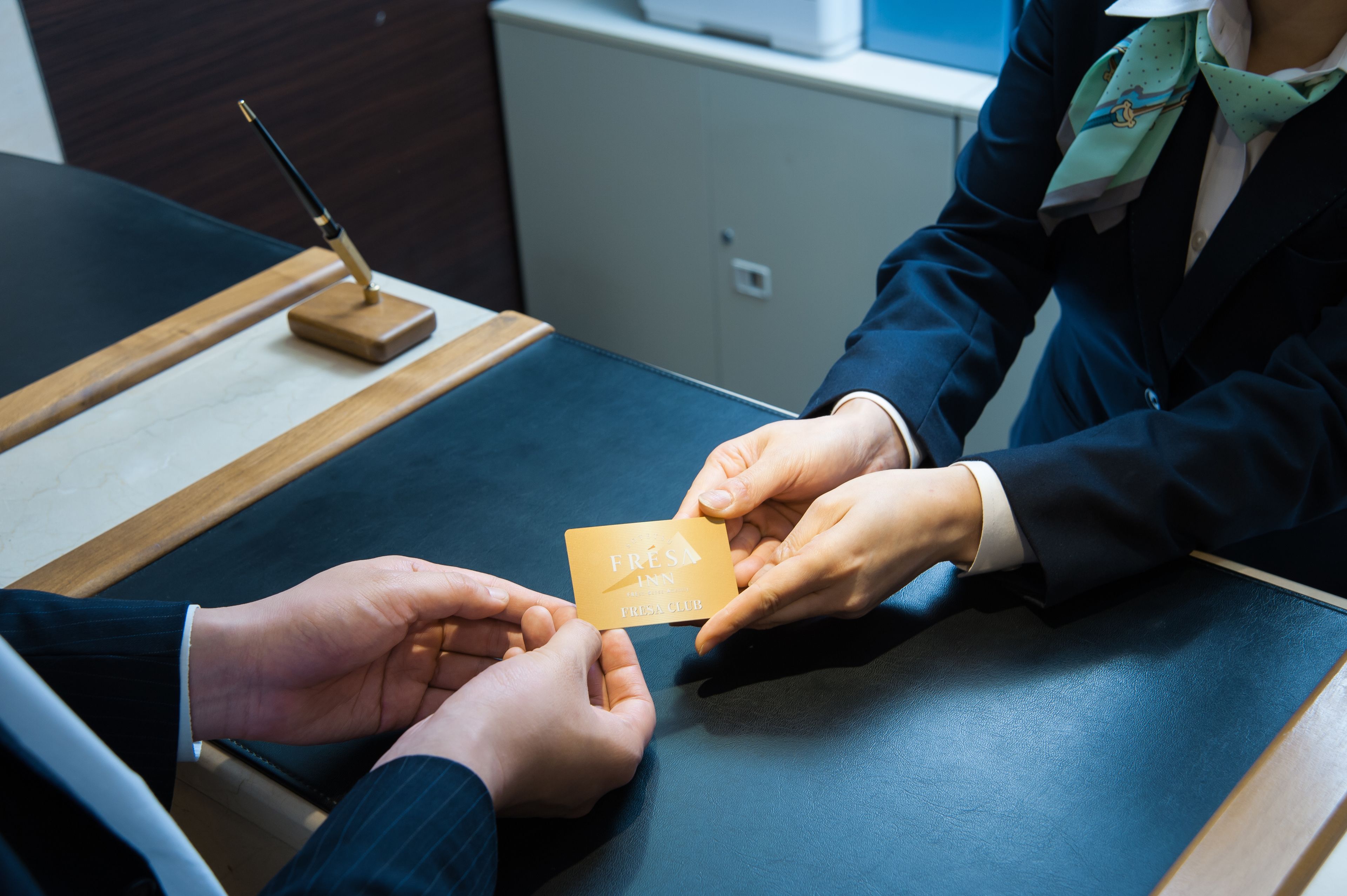 A business meeting with a card labeled "FRESA Inn" on a table.