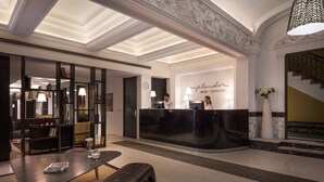 A hotel reception area with a modern design, featuring a reception desk, seating area, and a staircase. - Esplendor by Wyndham Montevideo Cervantes (Montevideo)