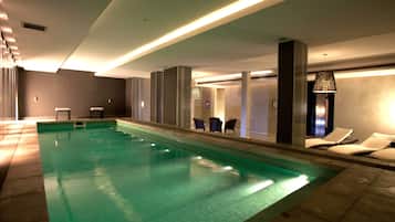 Relax by the pool with lounge chairs and tables nearby.