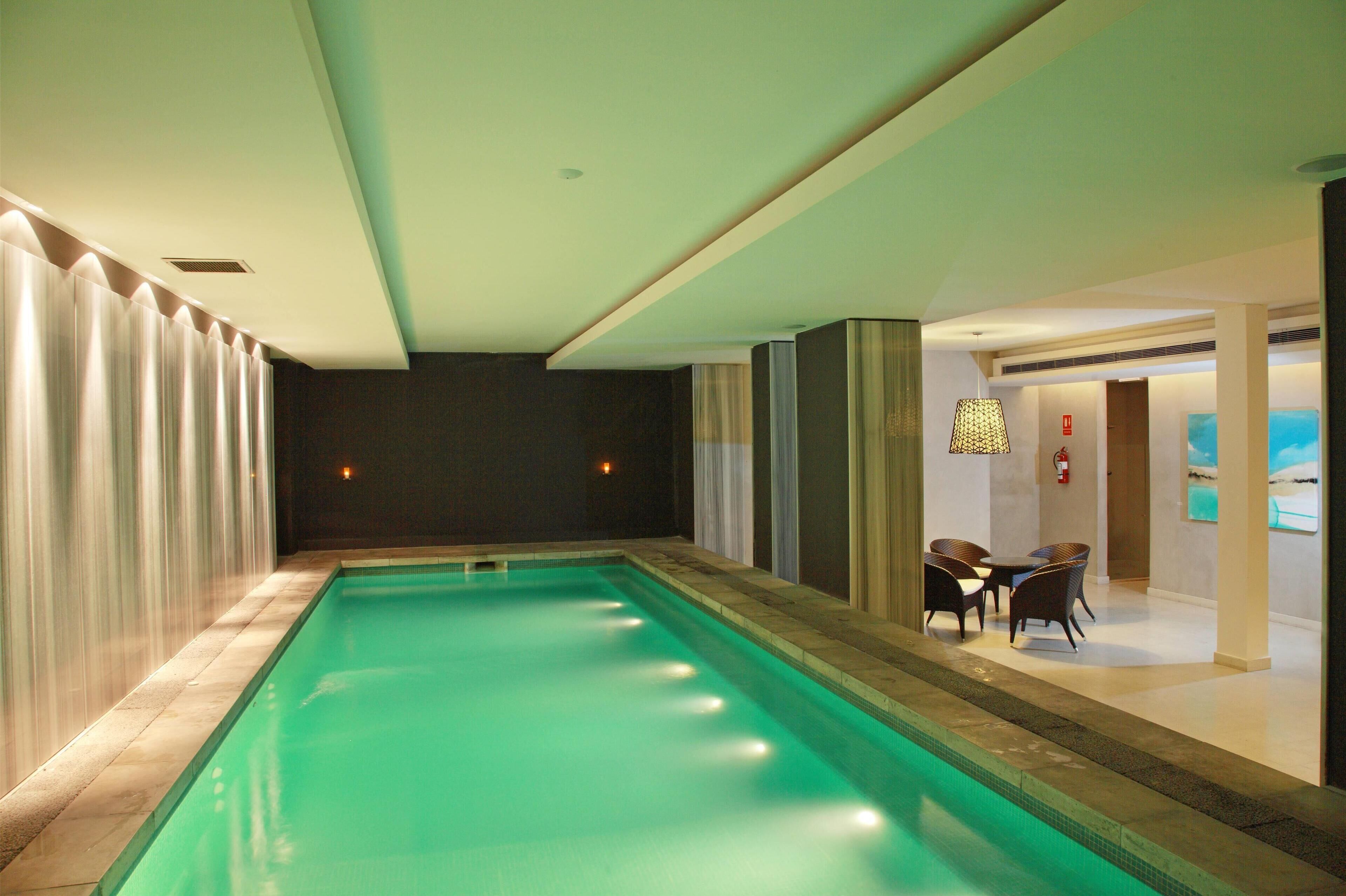 Una piscina con vista a un comedor y obras de arte en la pared.