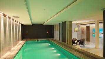 Una piscina con vista a un comedor y obras de arte en la pared.