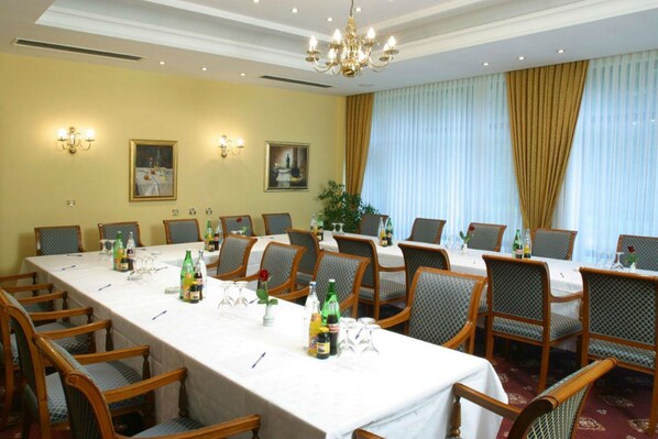 A conference room with a long table, chairs, and various items like bottles and glasses. - Hotel AS (Zagreb)