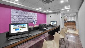 A reception area with two computer stations, a counter, and a seating area with chairs.