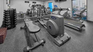 A gym with treadmills, elliptical machines, and free weights.