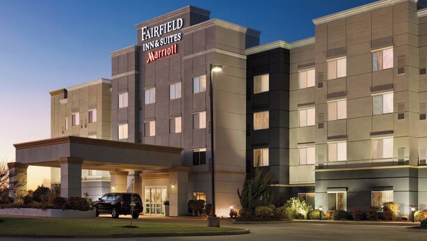 Un hôtel Fairfield Inn & Suites Marriott doté d’une façade moderne, d’une entrée abritée et d’un espace de stationnement.