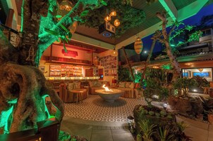 A bar area with a fire pit, seating, and a bar counter.