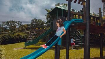 Un parque infantil con un tobogán y estructuras para escalar.