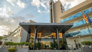 The entrance of the Golden Taurus Aquapark Resort with a modern architectural design, featuring a glass facade and a prominent entrance canopy. - Golden Taurus Aquapark Resort (Pineda de Mar)