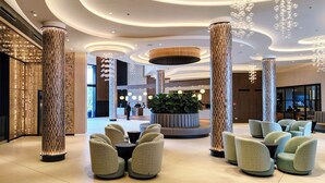 A modern lobby with unique columns, seating areas, and a reception desk. - Golden Taurus Aquapark Resort (Pineda de Mar)
